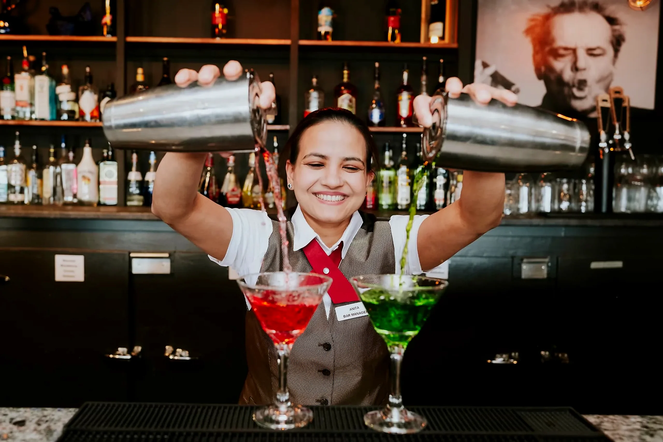 Cocktails poured to order Bar manager pouring two cocktails behind the bar at the Wabush Hotel