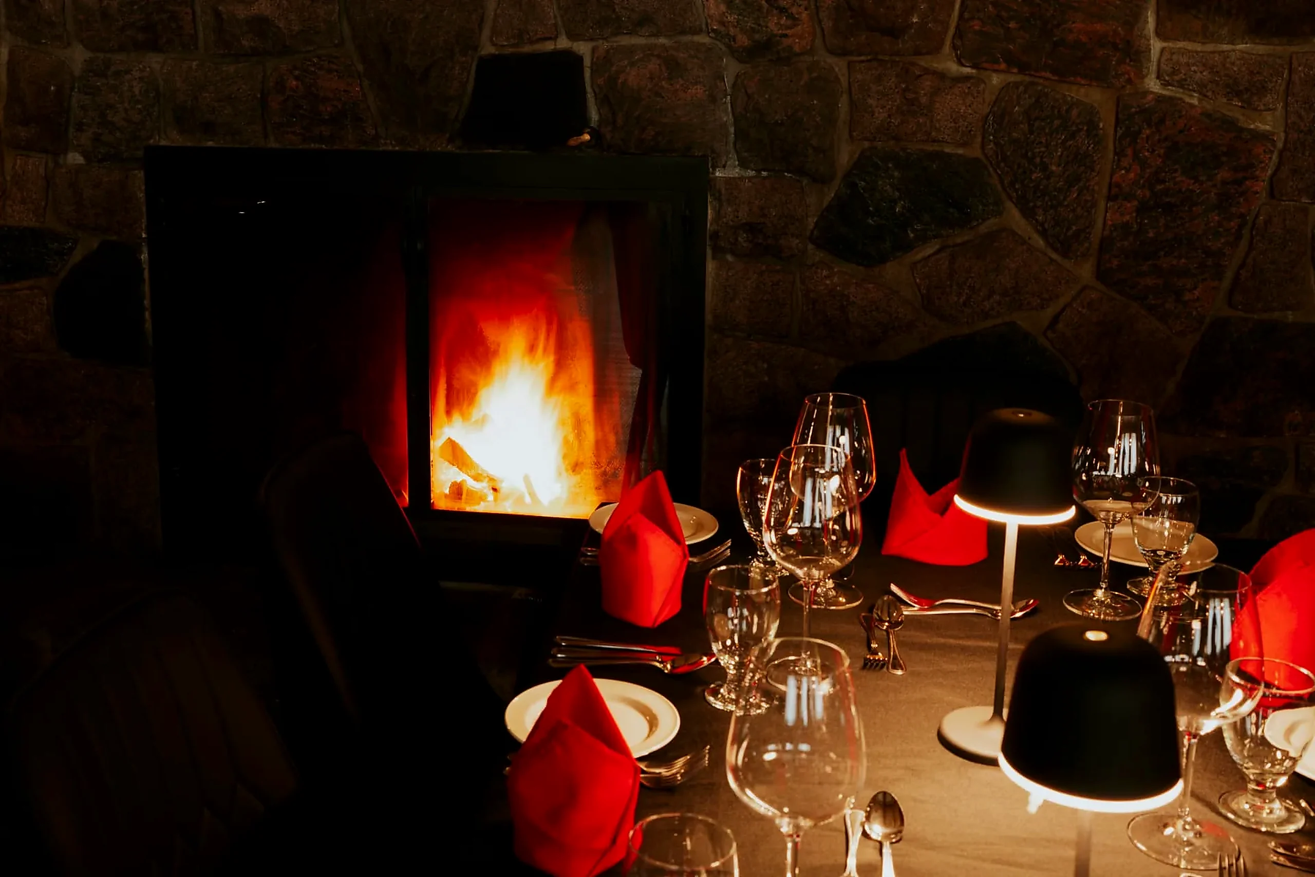 Fireside table Table set with red napkins directly in front of the restaurant fireplace
