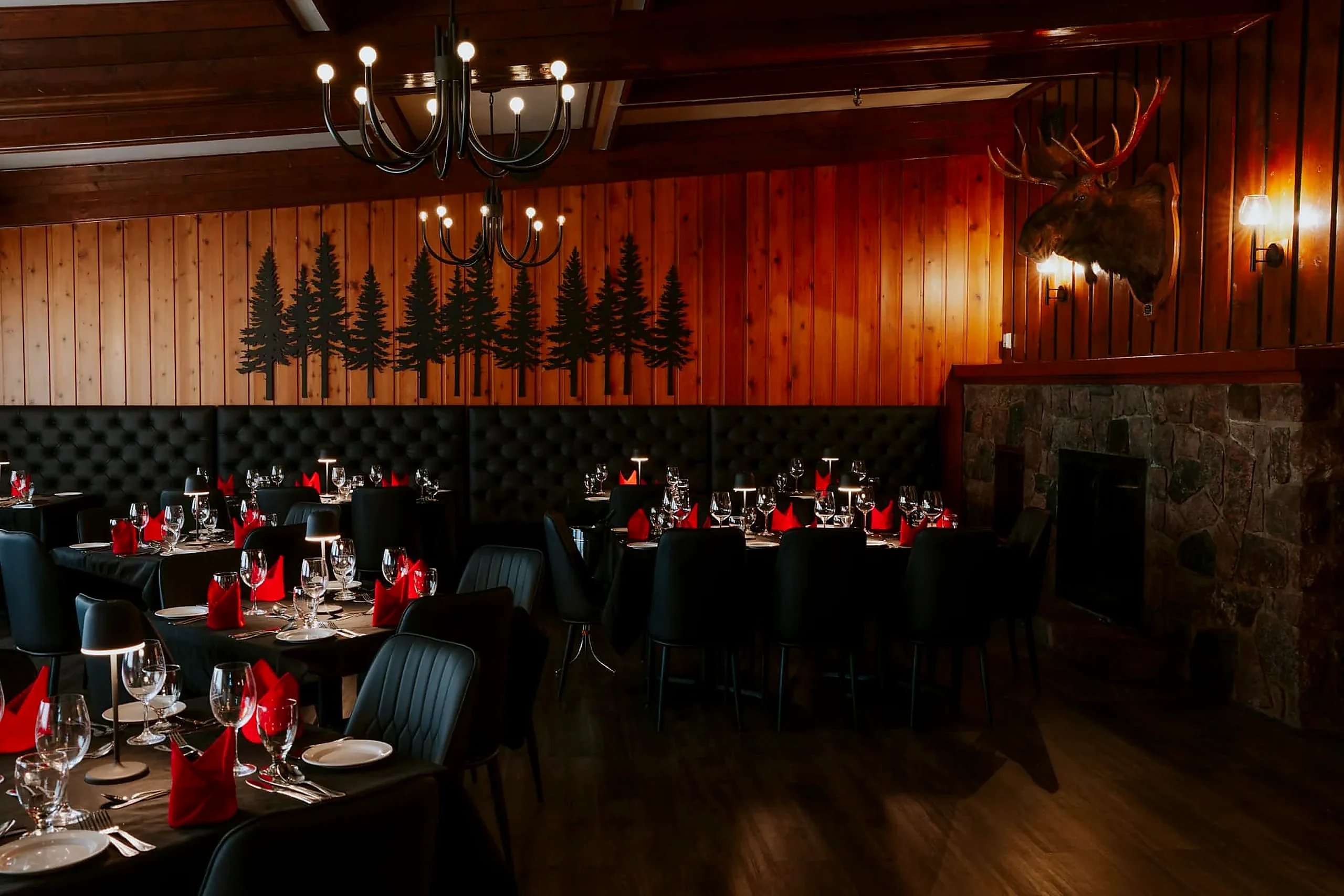 The Grenfell Restaurant dining room in Wabush with fireplace, chandeliers and tables set for supper The Grenfell Restaurant dining room in Wabush with fireplace, chandeliers and tables set for supper