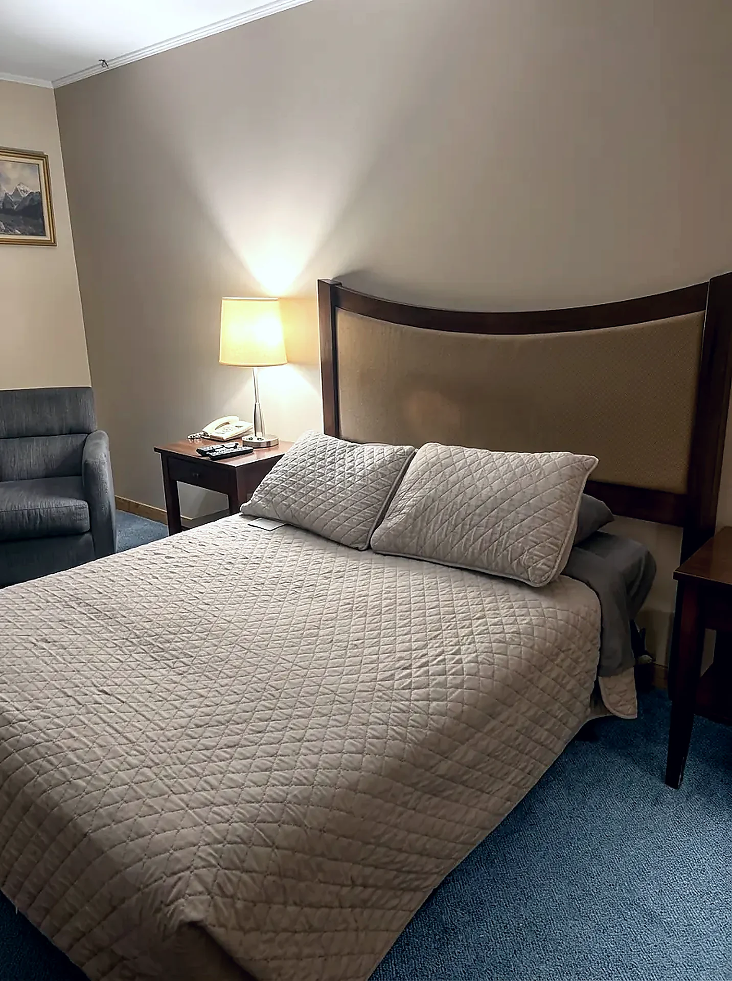 One double bed Standard guest room at the Wabush Hotel with one double bed, bedside lamp and an armchair