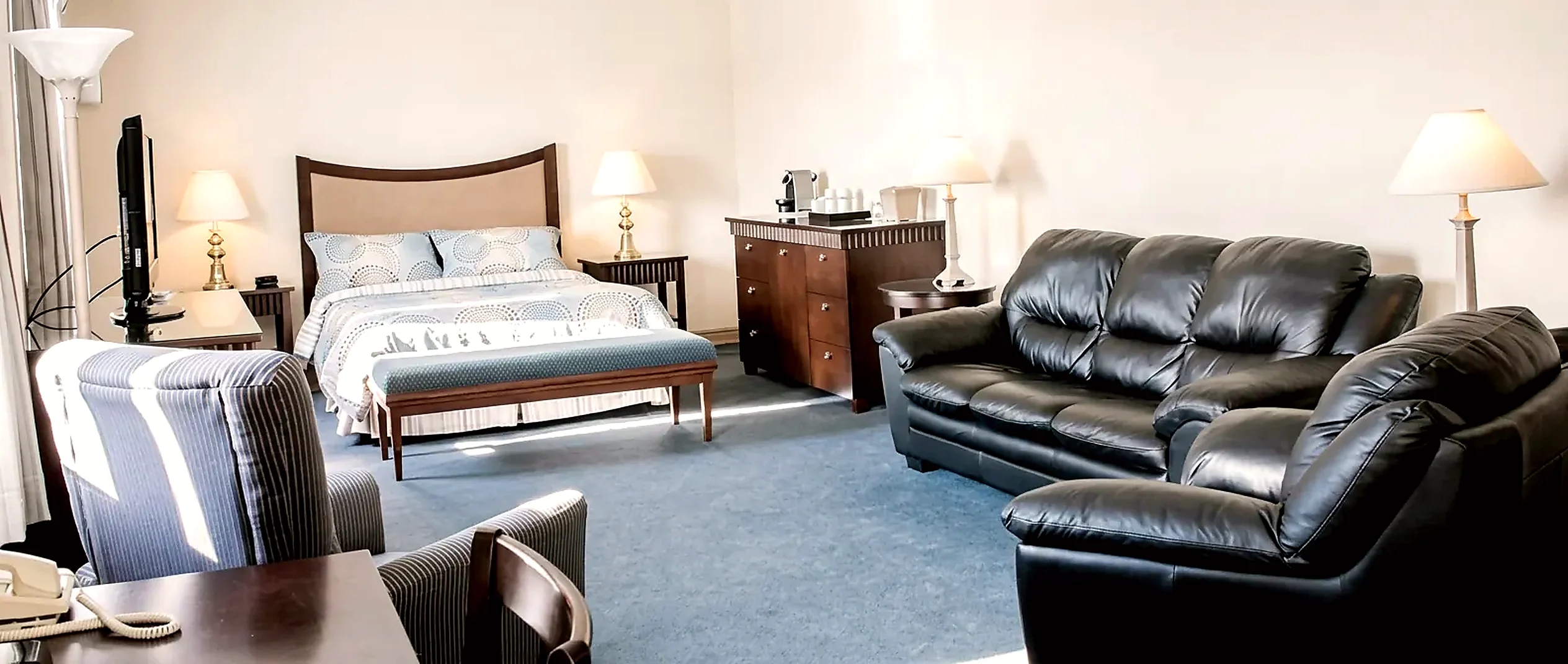 Suite Wabush Hotel suite with a bed, sofa and dresser in a separate sitting area