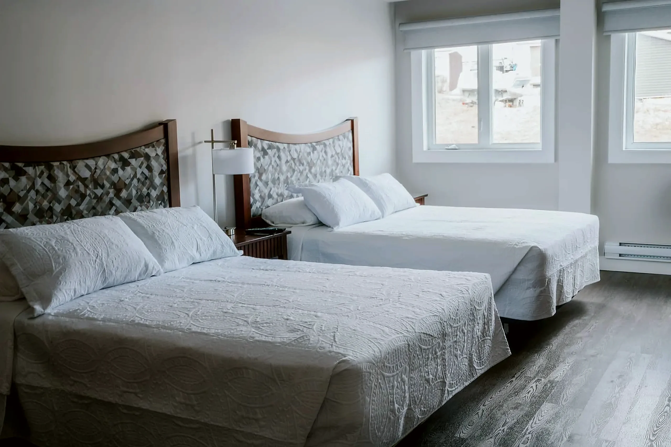 Two double beds Wabush Hotel guest room with two double beds and a window, suited to two workers sharing