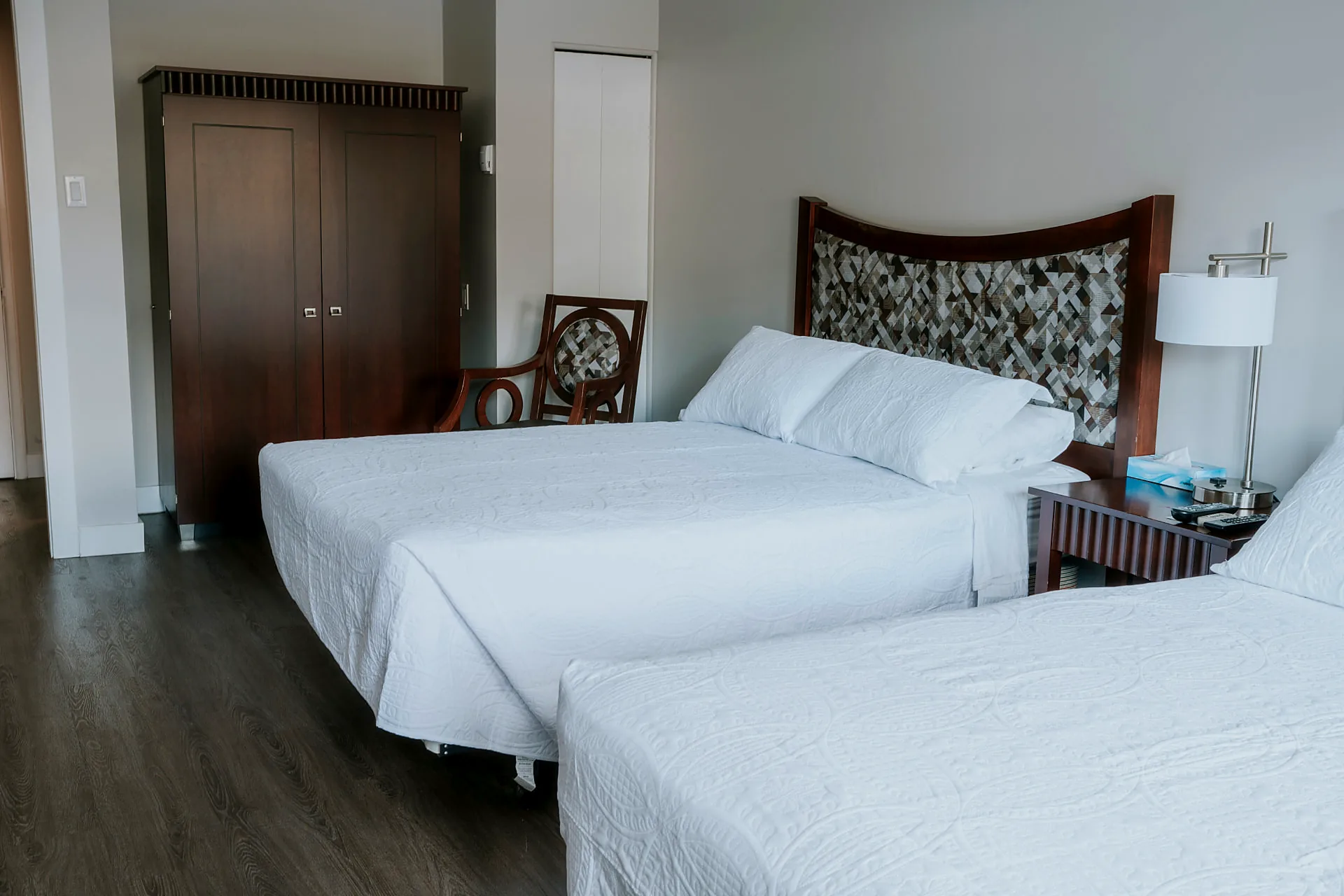 Renovated guest room Renovated Wabush Hotel guest room with two double beds, white bedding, a carved wood headboard and a window